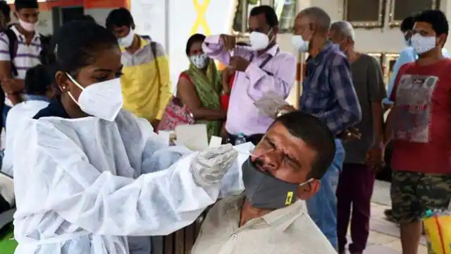 कोरोना : भारत में लगातार 6वें दिन 2000 से ज्यादा मामले दर्ज 1 a healthcare worker collects the swab sample of a passenger for rt pcr testing at dadar station in 1623122406
